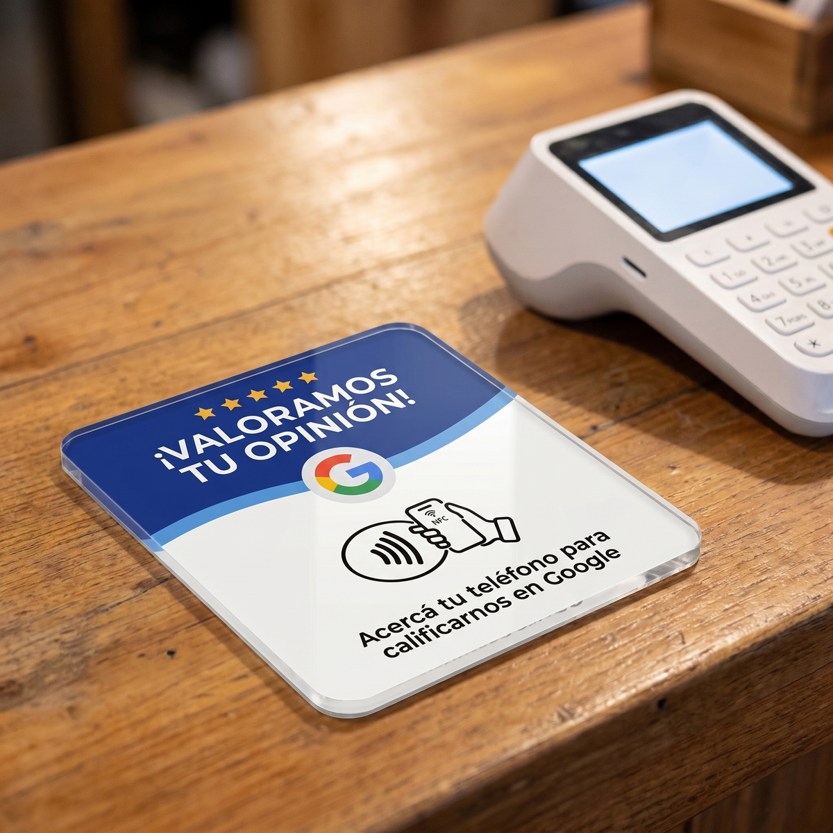 Placa NFC de Lumora Project adherida sobre un mostrador de madera junto a una terminal POS, lista para que los clientes acerquen su celular y dejen una reseña en Google.